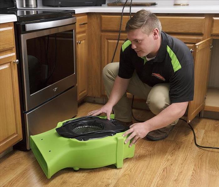 A SERVPRO crew member with an air mover.